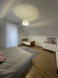 a bedroom with a bed and a dresser and a window at Domek pod lipami in Dwikozy