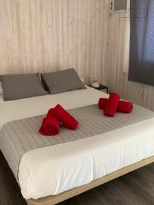 a bed with two red pillows on top of it at Single Fin Conil in Conil de la Frontera