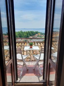 Habitación con vistas a un balcón con mesa y sillas. en Casa Rosita vista lago en Bolsena