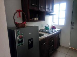 a kitchen with a refrigerator with a basket on it at Bungalow en la mejor ruta turística de Oaxaca in San Jerónimo Tlacochahuaya