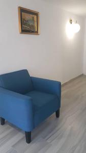 un divano blu in una stanza con un dipinto sul muro di Pace a Formello