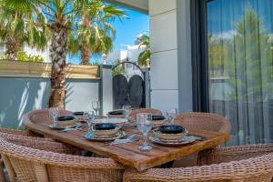 a wooden table with glasses and plates on it at Villa w Jacuzzi, Private Pool, Garden in Antalya in Belek