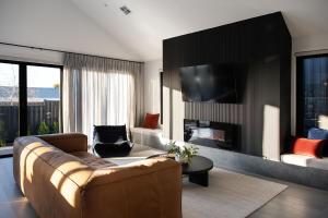 a living room with a couch and a tv at Scandi Haus- seamless design, modern luxury in Daylesford