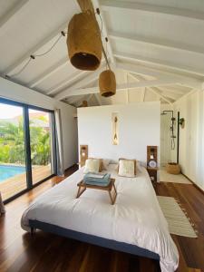 a bedroom with a large bed and a large window at ZANNANNA LODGE in Le Diamant