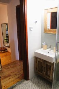 a bathroom with a sink and a mirror at The Sisters Beach House in Diliso