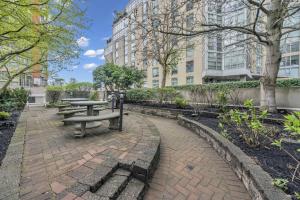 a picnic table and benches in a park with buildings at 1BD+Den condo, with free parking in Downtown! in Vancouver