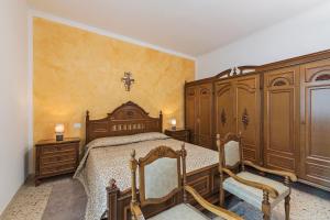 sypialnia z drewnianym łóżkiem i drewnianymi szafkami w obiekcie Casa MONTE CROCE w mieście Corbiolo