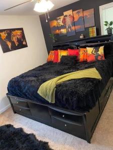 una camera da letto con un grande letto nero con cuscini colorati di NG-UGI Home a Lebanon