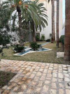 een binnenplaats met palmbomen en een gebouw bij Duplex à Hammamet centre in Hammamet Sud