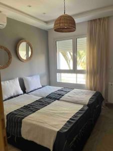 a bedroom with a large bed and a window at Duplex à Hammamet centre in Hammamet Sud