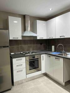 uma cozinha com armários brancos e um forno com placa de fogão em Duplex à Hammamet centre em Hammamet Sud