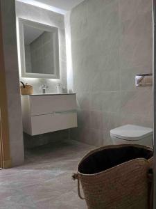 een badkamer met een wastafel, een toilet en een spiegel bij Duplex à Hammamet centre in Hammamet Sud