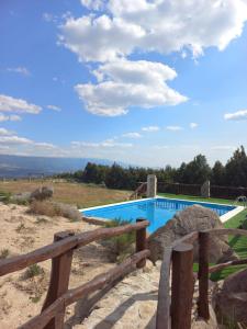 a swimming pool with a wooden fence around it at Quinta Do Marmeiral in Mangualde