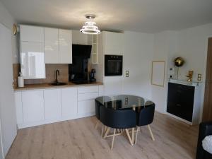 uma cozinha com uma mesa de vidro e cadeiras pretas em Appartement sublime em Romainville