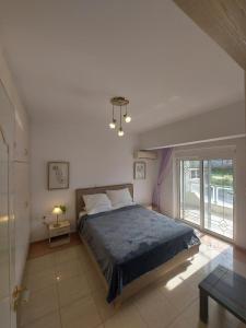 a bedroom with a bed with a blue comforter at Adromeda Aegean Sea View villa in Koskinou