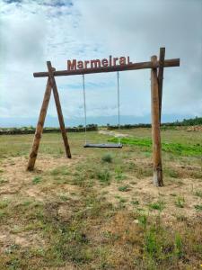 a sign with a swing in the middle of a field at Quinta Do Marmeiral in Mangualde
