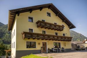 una grande casa gialla con balcone in legno di Haus Waldrast a Kappl