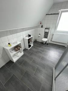 ein Badezimmer mit Fliesenboden und einem Baby im Regal in der Unterkunft Domo Dolce Wohnapartment 