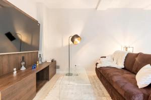 salon z brązową kanapą i lustrem w obiekcie Cocoon du vieux Lyon - Luxury apartment - Balneo w mieście Lyon