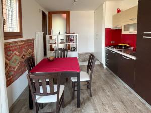uma cozinha com uma mesa vermelha e cadeiras num quarto em Apartment Claudia Malcesine em Malcesine