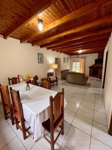 a dining room with a table and a living room at Chacara Recanto dos Pássaros in Camanducaia