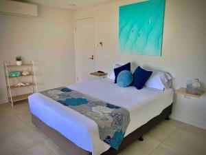 Airlie Beach的住宿－Whitsunday Dreams，一间卧室配有一张带蓝色枕头的大床