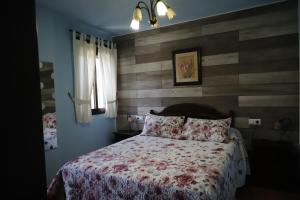 1 dormitorio con 1 cama con pared de madera en Plaza de los asomaderos 54 Grazalema, en Grazalema