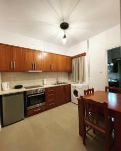 a kitchen with wooden cabinets and a table with a dining room at Mano’s House Preveza 2 in Preveza
