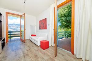 uma sala de estar com um sofá branco e uma porta de vidro deslizante em Apartment Claudia Malcesine em Malcesine