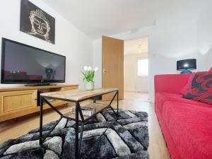 un soggiorno con divano rosso e TV di Tree View Apartment a Chesterton