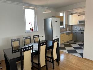 a kitchen with a table with chairs and a refrigerator at Spacious 3-bedroom Condo Next to City Center in Pristina