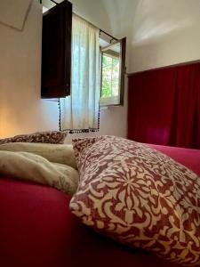 1 dormitorio con cama con almohada y ventana en Bouganville-La Casa Dei Fiori, en Pantelleria