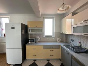 a kitchen with a white refrigerator and a sink at Spacious 3-bedroom Condo Next to City Center in Pristina +21 photos