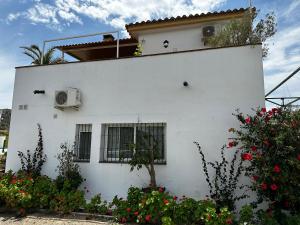 een wit huis met bloemen ervoor bij Casa Luz in Málaga