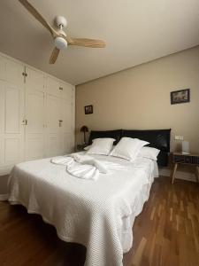 Schlafzimmer mit einem weißen Bett und einem Deckenventilator in der Unterkunft Casa rural Villa Verde in Tudela