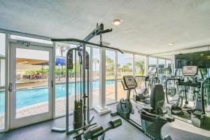 a gym with several treadmills and a swimming pool at Pelican Beach Resort 1205 in Destin