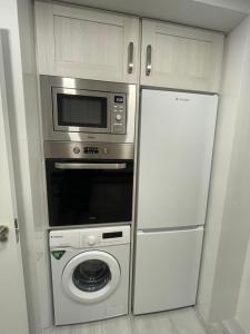 a kitchen with a microwave oven and a refrigerator at Apartamento de lujo en Cullera con Aire Acondicionado y posibilidad de Parking in Cullera