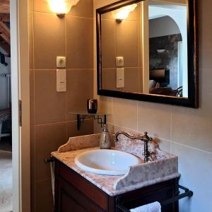 een badkamer met een wastafel en een spiegel bij CASA PAVÃO (SALGADINHO - SELÃO DA EIRA) in São Teotónio