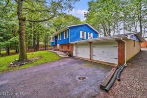a blue house with a garage and a driveway at Sauna, Games,Grill, View,Lake,Pool,TVs in Albrightsville