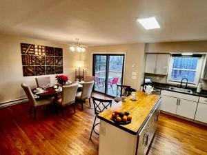 a kitchen and living room with a table and a dining room at Sauna, Games,Grill, View,Lake,Pool,TVs in Albrightsville