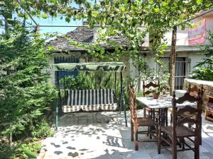 um pátio com uma mesa e um guarda-chuva verde em "Villa 70" Guesthouse em Gjirokastër