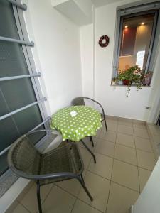 a table and chairs in a room with a window at Sofy Center Apartment (Free Parking) in Novi Sad