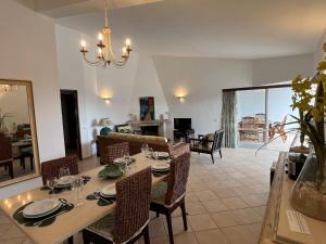 comedor y sala de estar con mesa y sillas en Vila Rosa - Private Swimming Pool With Sea View, en Albufeira