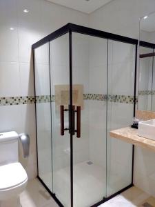 uma cabina de duche em vidro numa casa de banho com WC em Guess Hotel & Motel em Guarulhos