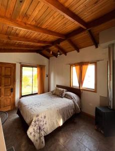 una camera con letto in una stanza con soffitti in legno di Cabañas Doña Mónica a Recinto