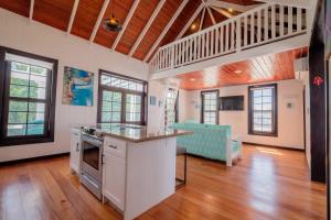 a kitchen and living room with a counter and a table at Caribbean Vacation Rentals and The PoolClub at Mahogany! in San Pedro