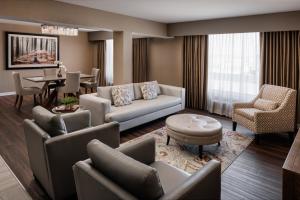 ein Wohnzimmer mit Sofas und ein Esszimmer in der Unterkunft Pomeroy Hotel & Conference Centre in Grande Prairie