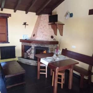 a dining room with a table and a fireplace at Apartamento" El Carballo" in San Tirso de Abres