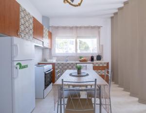 a kitchen with a table and chairs and a refrigerator at VillaBlu Apartments in Asgourou