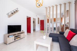 a living room with a blue couch and a tv at VillaBlu Apartments in Asgourou